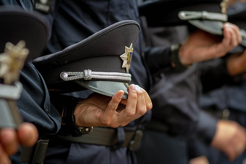 форменная фуражка в руках полицейских