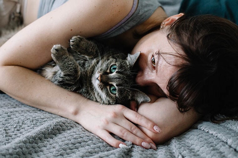 Крупным планом женщина обнимает кошку