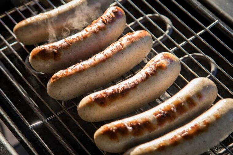 Немецкая свиная колбаса Bratwurst на электрическом гриле для барбекю