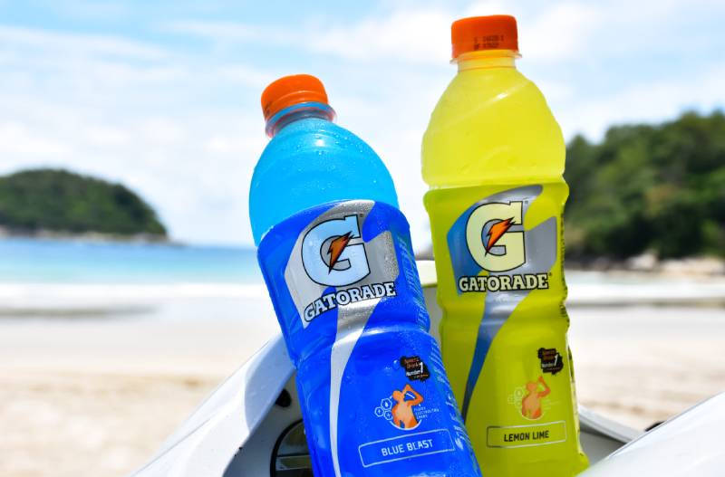 две бутылки напитка Gatorade на пляже в качестве фона